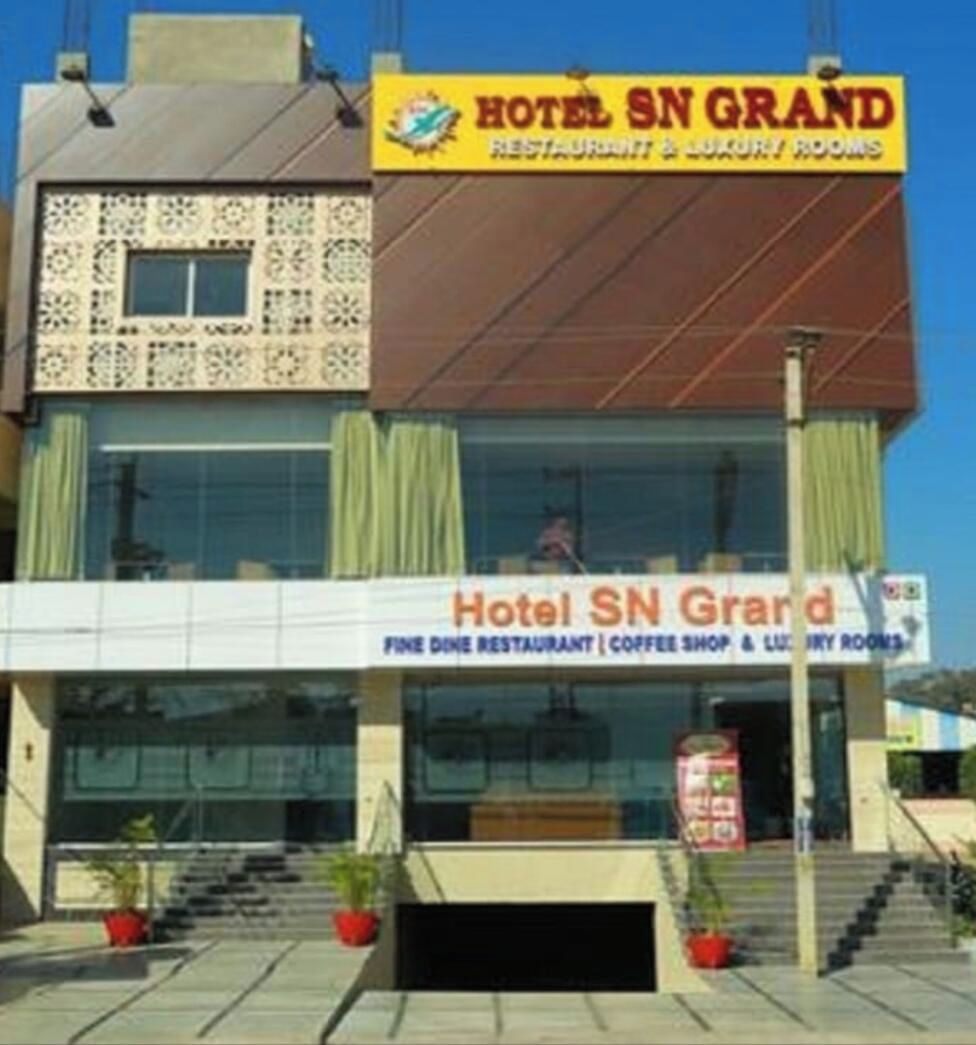 Un bâtiment portant une enseigne « Hôtel SN Grand », indiquant qu’il propose un restaurant gastronomique, un café et des chambres de luxe.