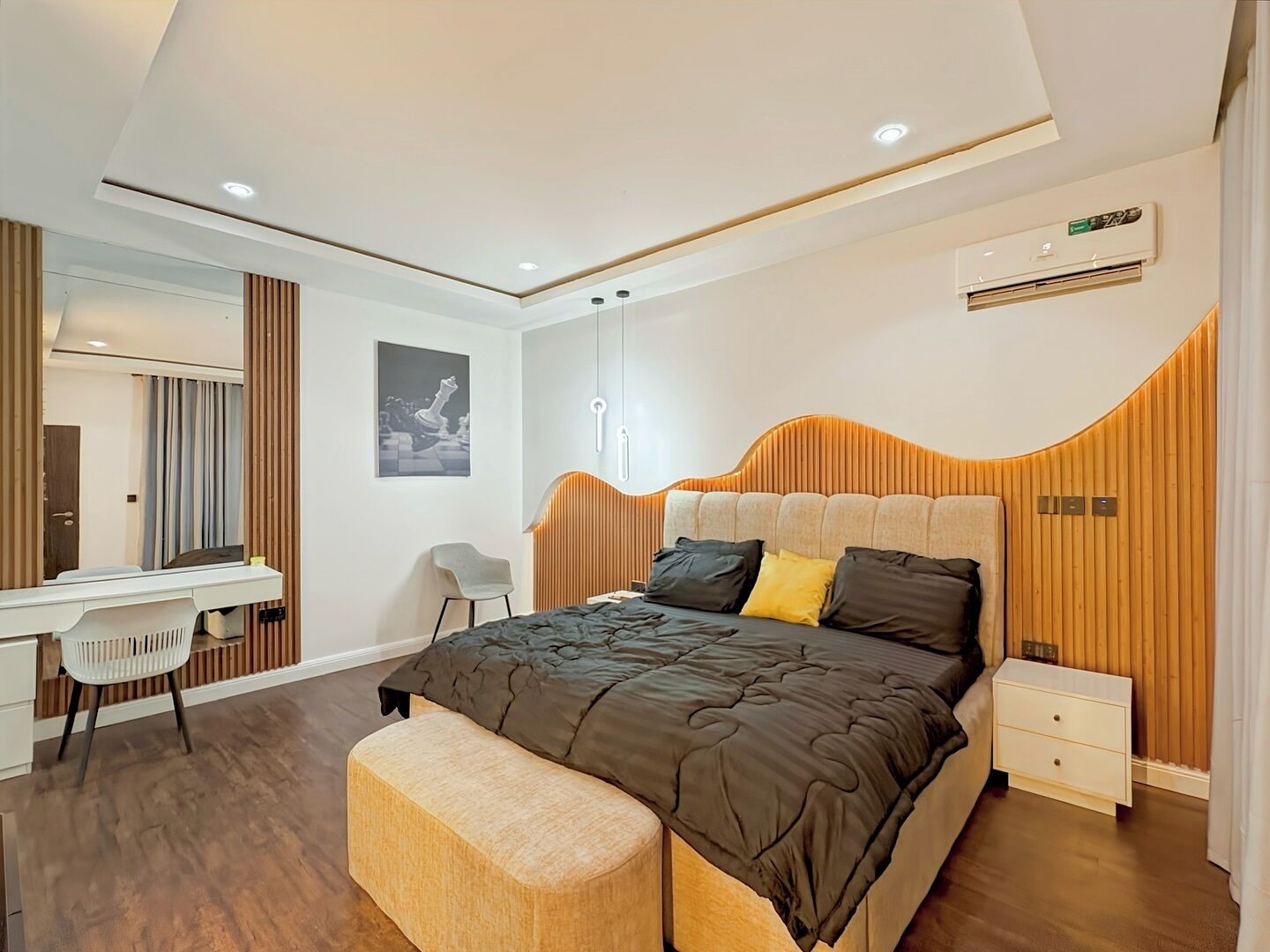A modern bedroom with a bed, bedside tables, a desk, and a chair.
