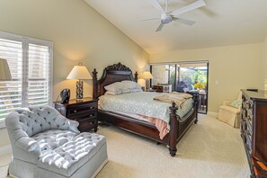 A bedroom with a large bed, a tufted armchair, a dresser, and a ceiling fan. - Golf Course View, Pool & Lanai! Upscale Naples Gem (Naples)