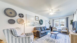 A living room with a sofa, armchair, coffee table, and decorative wall art. - 1 Mi to Park Circle: Pet-Friendly Home w/ Yard (North Charleston)
