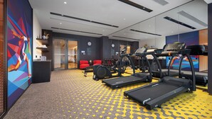 A modern hotel gym with treadmills, weight machines, and red chairs. - Hampton by Hilton Yichun  (Yichun)