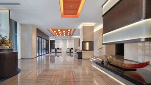 A spacious lobby with a polished floor, a reception desk, and a modern ceiling design. - Hampton by Hilton Yichun  (Yichun)