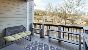 A covered porch with a bench and a table, overlooking a street with parked cars and houses. - 6 Mi to Broadway: Nashville Townhome w/ Balcony! (Nashville)