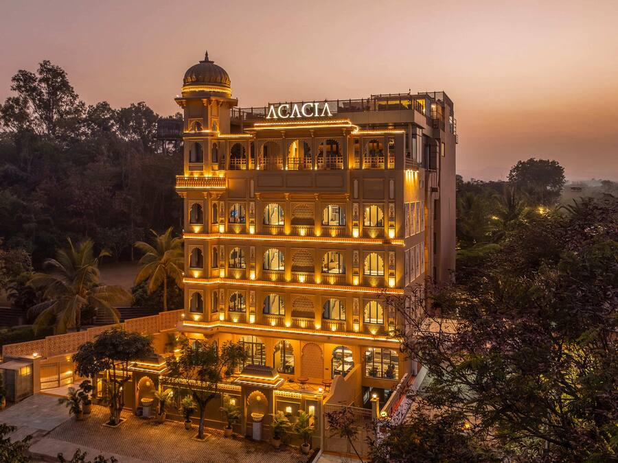 A multi-story building with a prominent dome and the name "ACACIA" illuminated at the top.