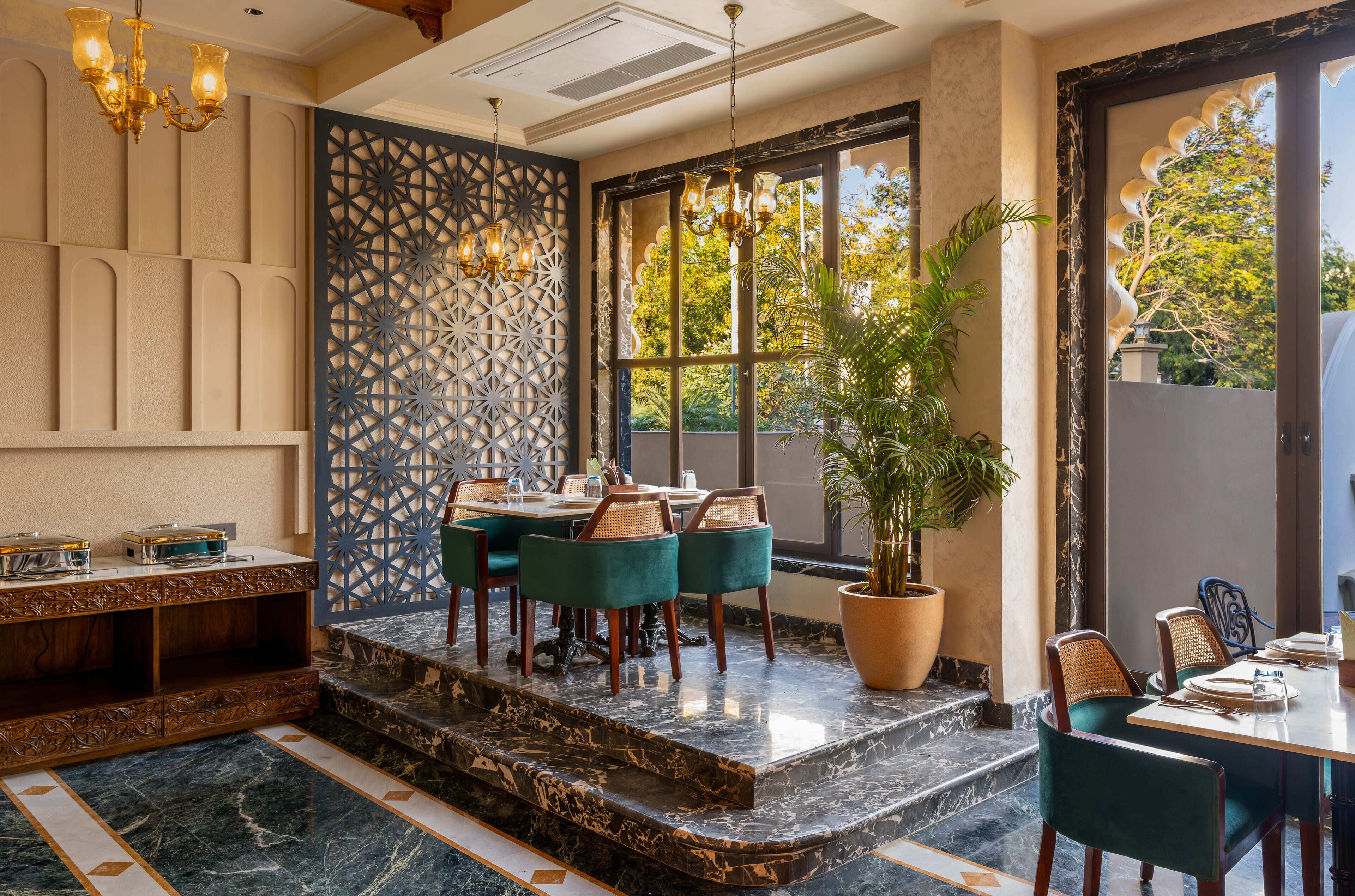 A dining area with a marble floor, a patterned wall, and a large window with a view of trees.