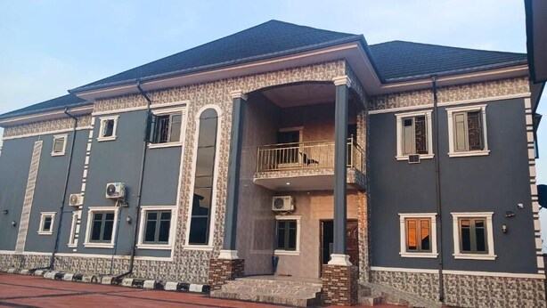 A two-story building with a balcony, large windows, and a red-tiled entrance. - J-D Suites (Ozuoba)