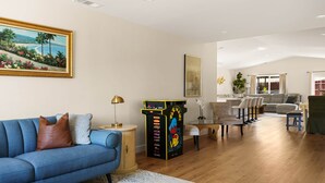 Una sala de estar con un sofá azul, una mesa de centro y un cuadro en la pared.
