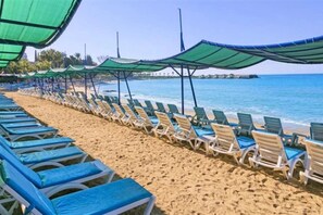 Aurinkotuoleja, aurinkovarjoja, rantapyyhkeitä