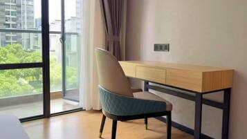 A modern room with a large window, a desk, and a chair.