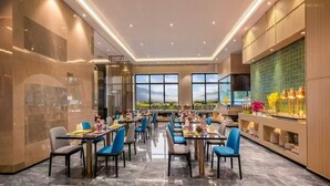 A modern dining area with tables and chairs, large windows, and a view of the outdoors. - RAY TOUR (Zhaoqing)