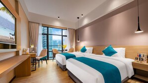A hotel room with two beds, a desk, a chair, a TV, and a large window with a city view. - RAY TOUR (Zhaoqing)