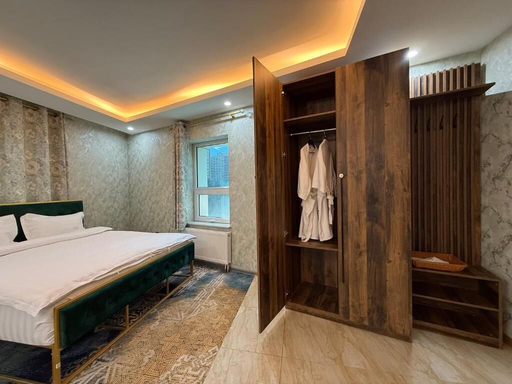 Quarto com cama, guarda-roupa de madeira e janela.