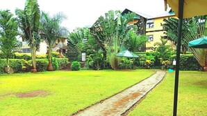 Un jardín bien cuidado con un sendero que lleva a un edificio con varios balcones.