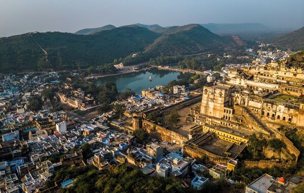 An aerial view of a historic city with dense urban development, a prominent fort, and a river. - Annpurna Haveli (Bundi)