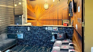 A hotel lobby with a marble reception desk, a sofa, a patterned rug, and a wooden accent wall. - Shri Kamal Dham Hotel Vrindavan (Vrindavan)