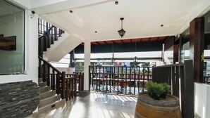 A modern interior with a staircase, a wooden barrel, and a view of the outside. - Hotel 198 Negombo (Negombo)