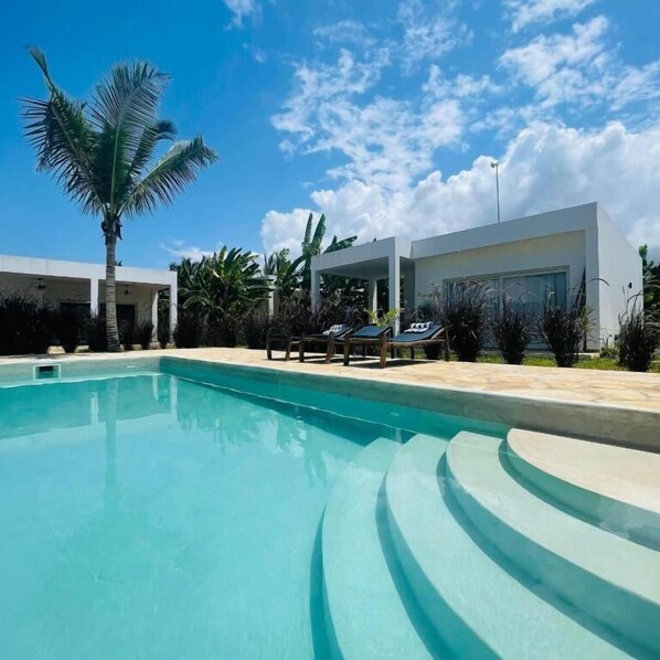 A swimming pool with a modern house in the background.