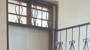 A white door with a metal gate and decorative metalwork. - Furnished Flat Apartment Bamburi Beach Mombasa (Mombasa)