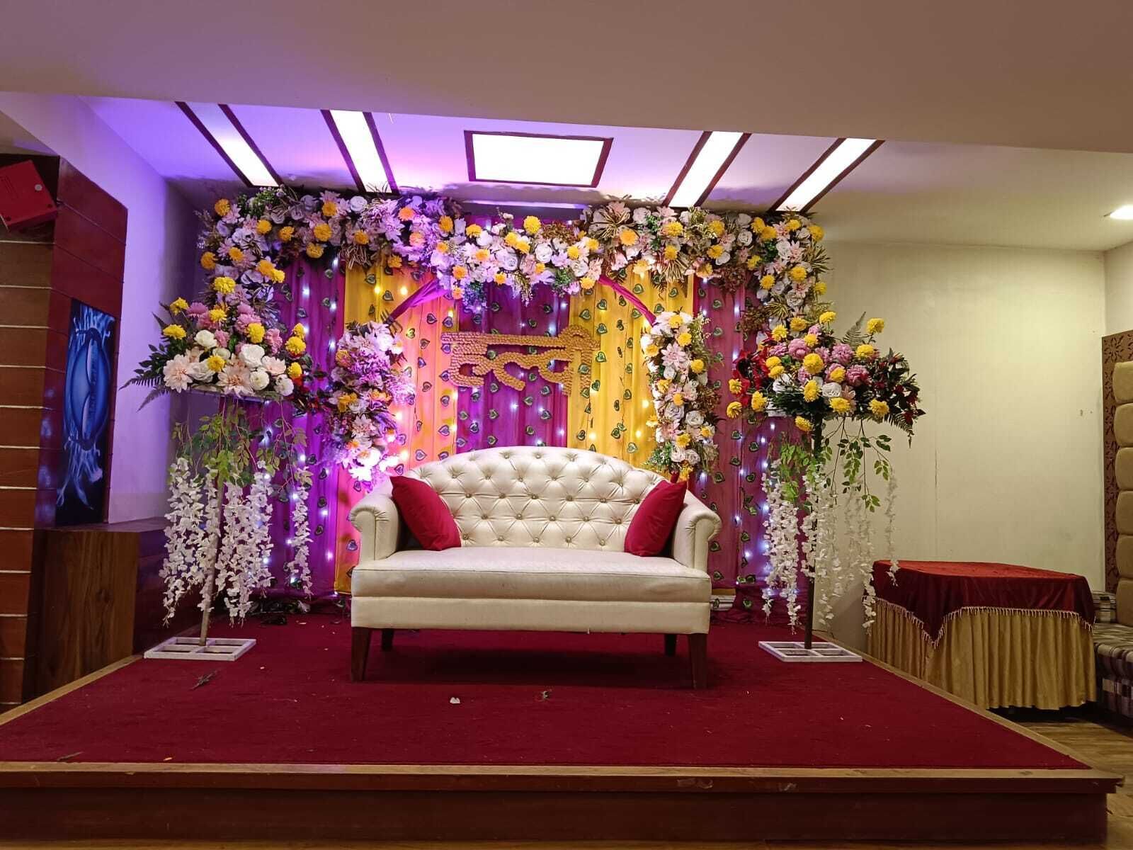 A stage with a white sofa, red cushions, and a red carpet.
