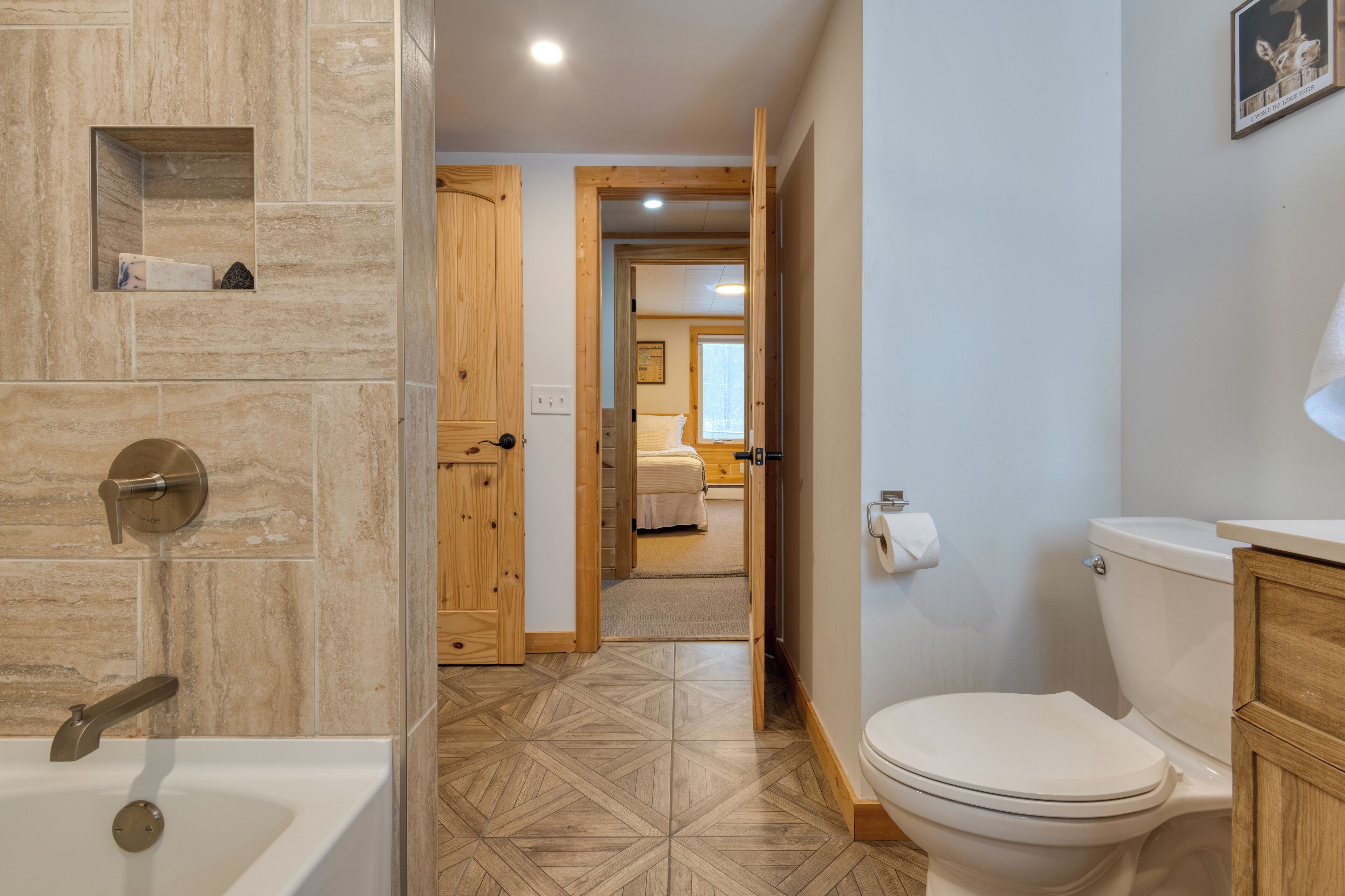 Un baño con bañera, inodoro y armarios de madera.