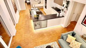 A modern living room with a blue armchair, a grey sofa, and a patterned rug. - Penthouse with XL terrace | including parking space | top connection to the old town (Nürnberg)