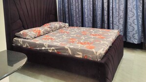 A modern bedroom with a large bed, dark headboard, and a ceiling fan. - Private Stylish Flat in Nyali Mombasa with Pool near Beach (Mombasa)