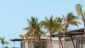 Um resort moderno com piscina, espreguiçadeiras e palmeiras.