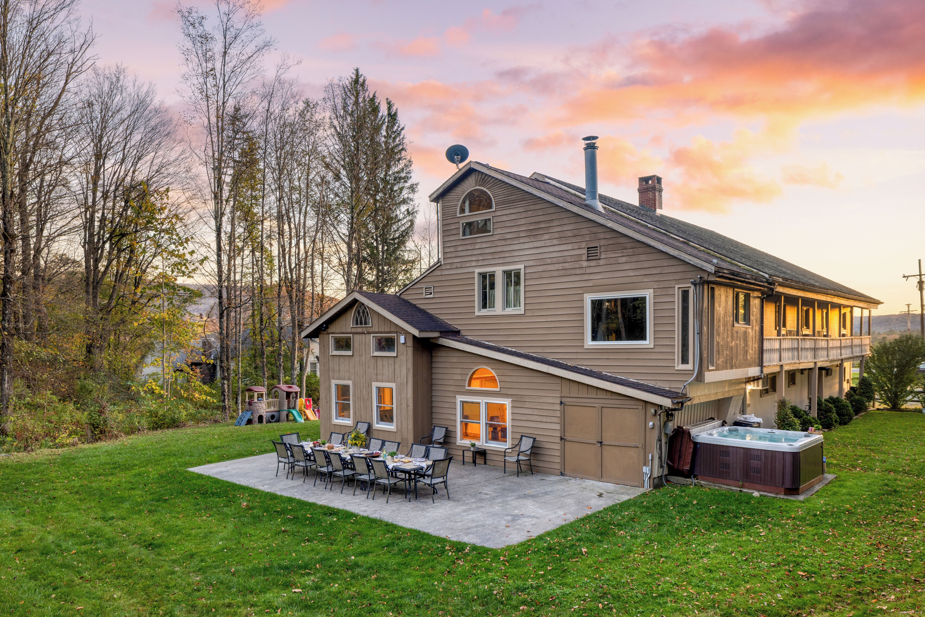 Une maison à deux étages dotée d’un patio, d’un jacuzzi et d’une terrasse.