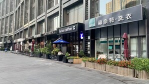 Une rue bordée de boutiques, dont un café et un magasin Fornet.