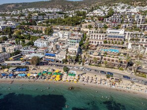 Uma vila costeira com praia, hotéis e uma combinação de edifícios residenciais e comerciais.