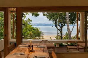 Un comedor con vistas a la playa y las montañas.