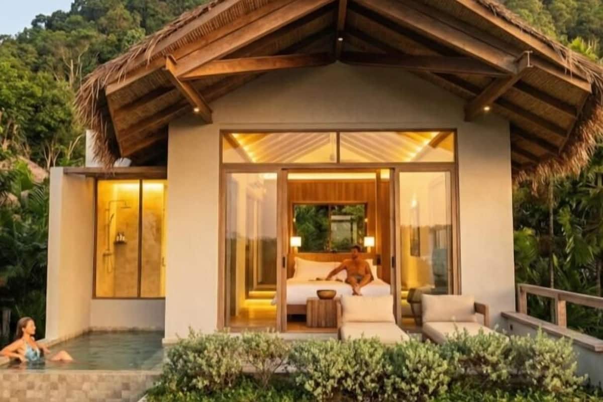 Une villa moderne dotée d’une piscine, d’une chambre avec une grande fenêtre et d’un balcon agrémenté de verdure.