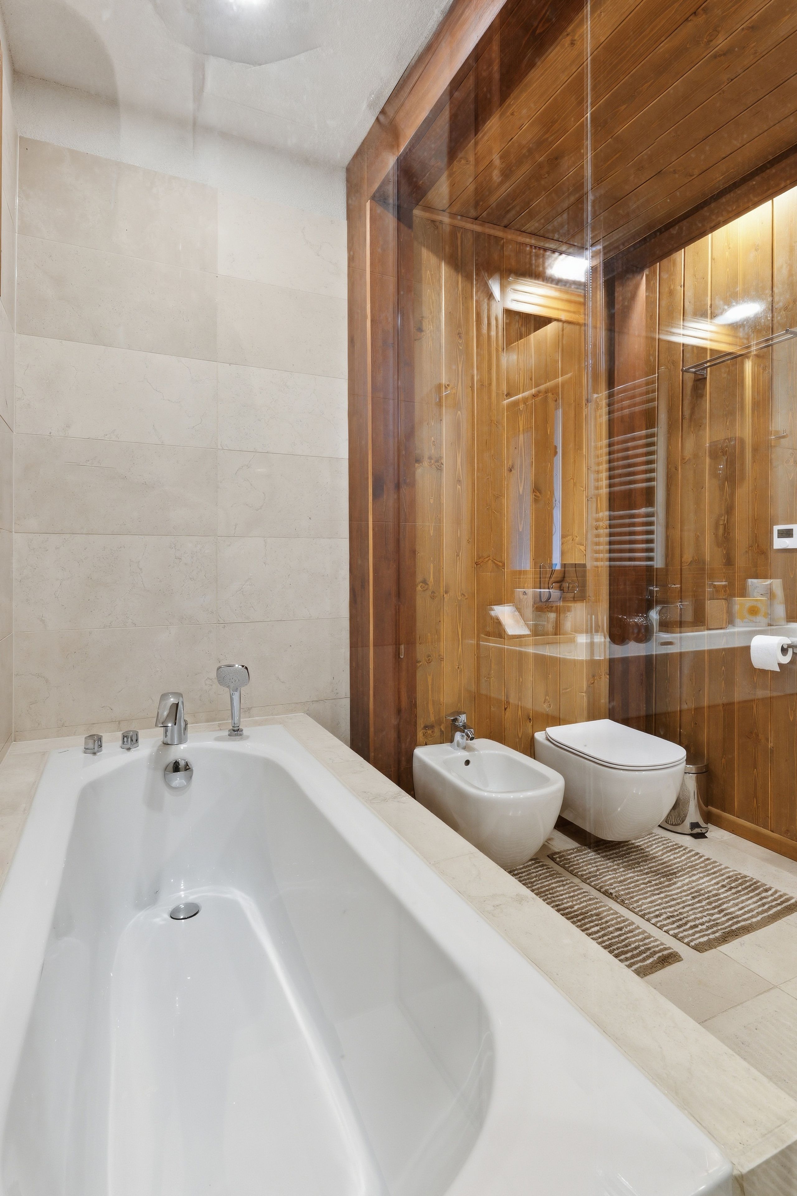 A bathroom with a large bathtub, a separate bidet, and a toilet.