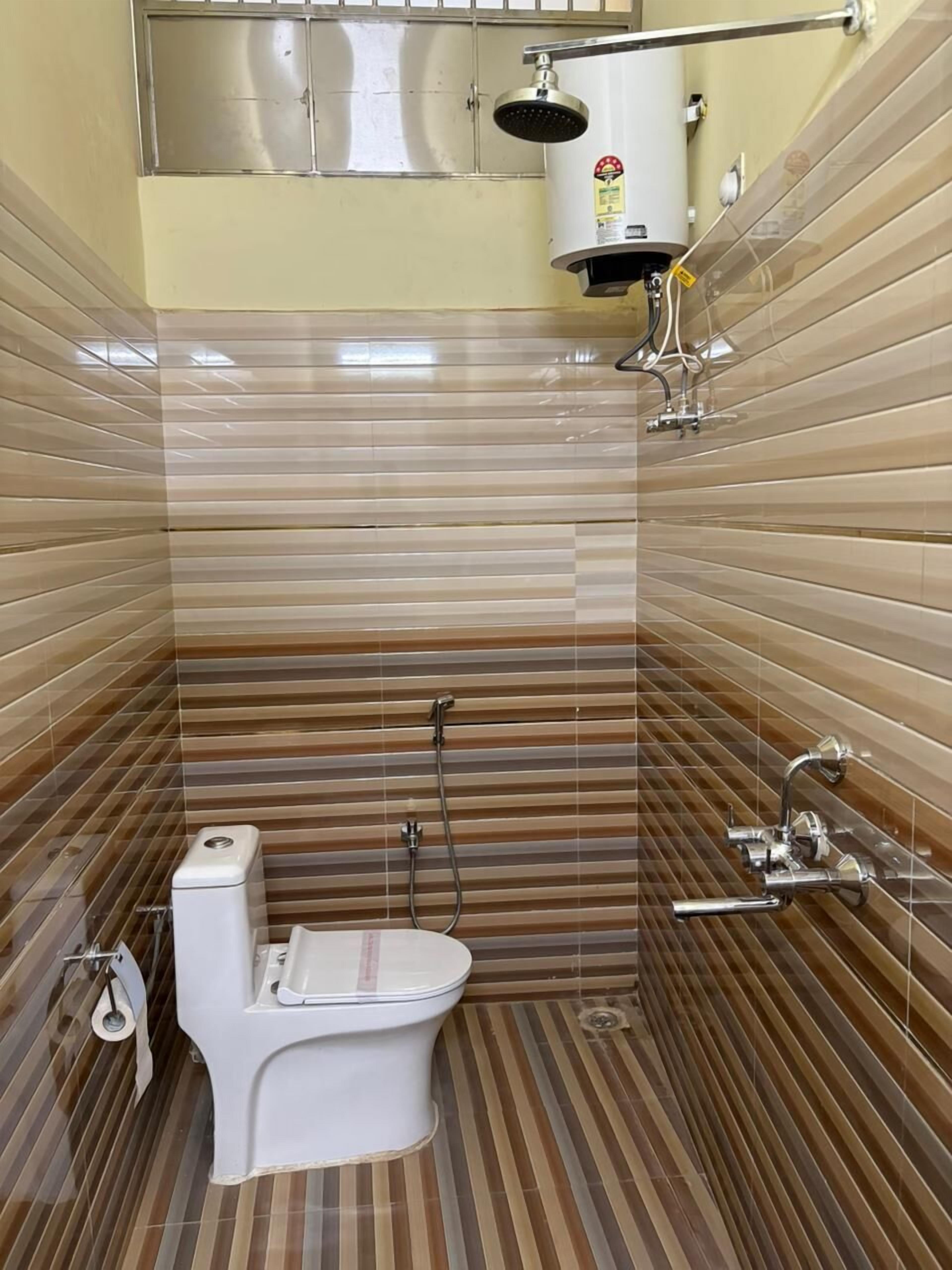 Ein kleines, modernes Badezimmer mit Toilette, Dusche und Warmwasserbereiter.
