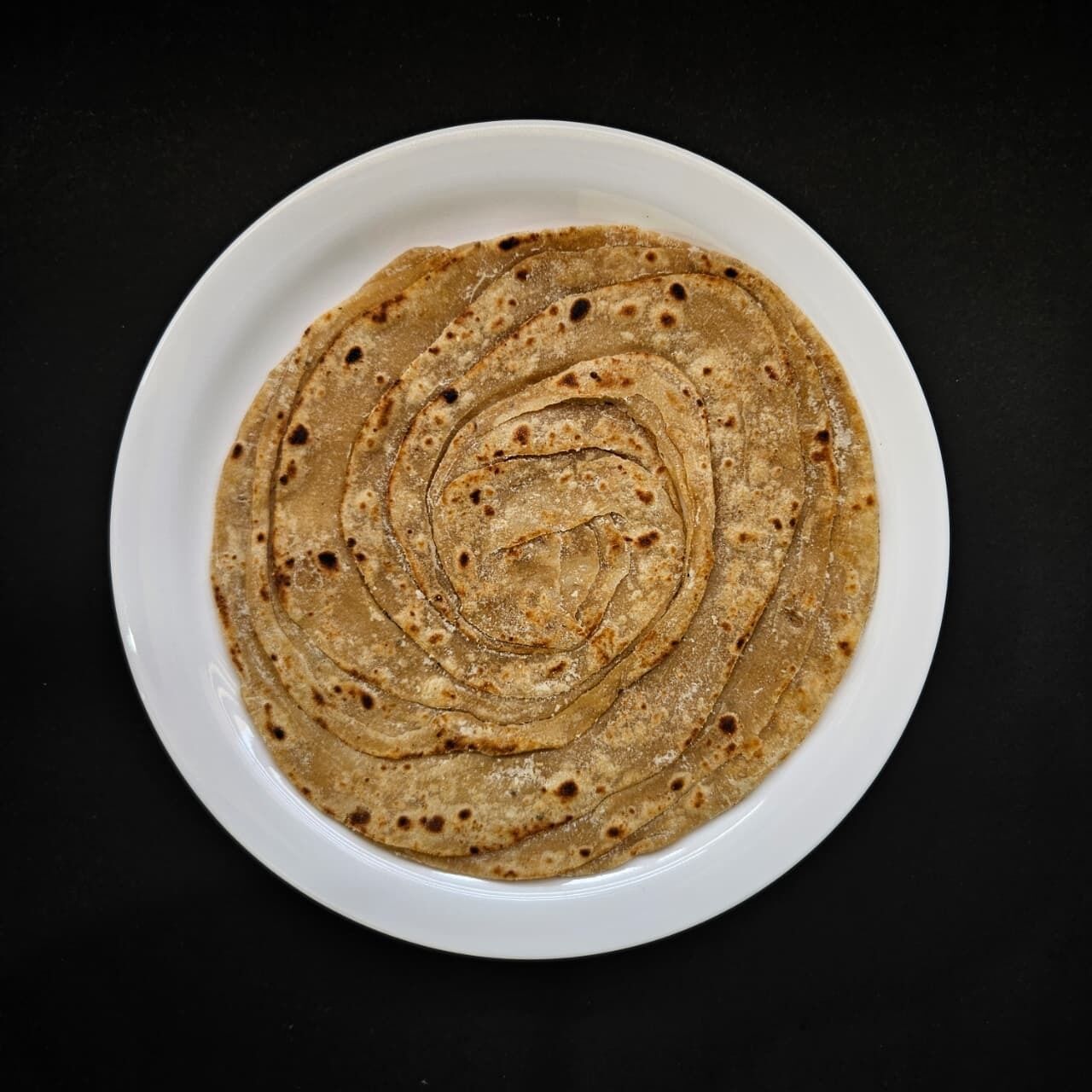 A white plate with several flatbreads arranged in a circular pattern.