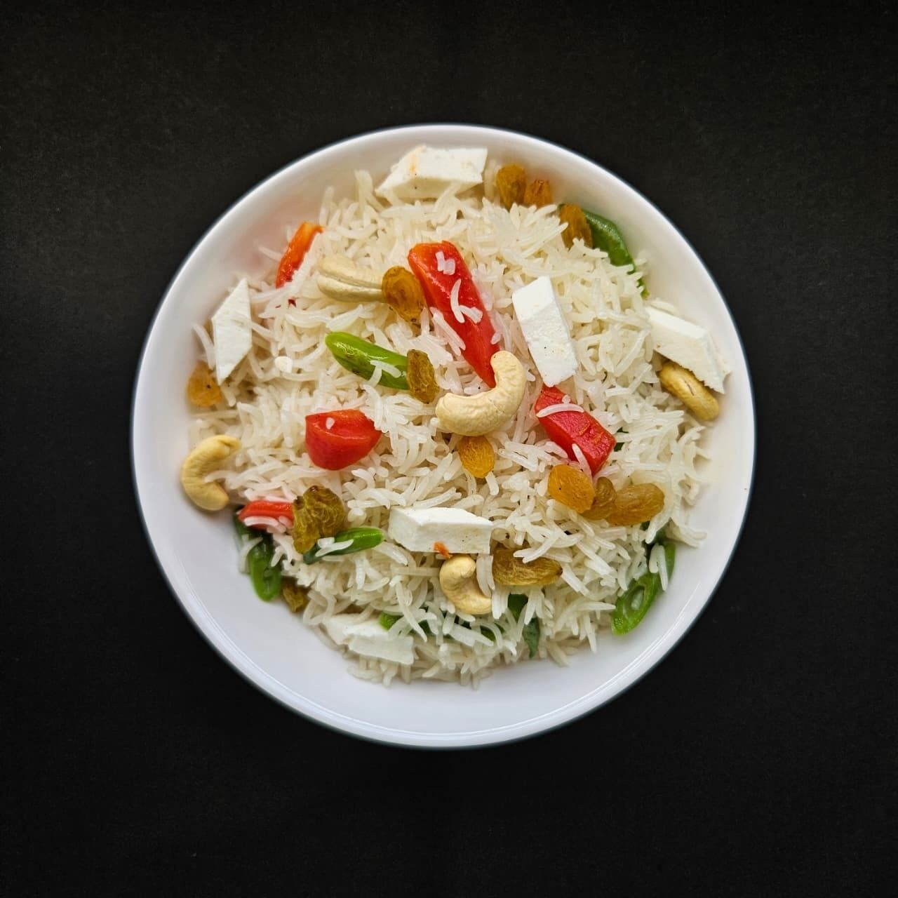 Una ciotola di riso con verdure e frutta secca.