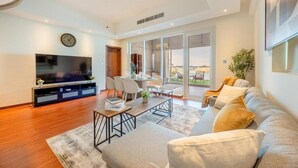 A modern living room with a flat-screen TV, a dining area, and a sofa. - Unit 805 Jamam Residence (Abu Dhabi)
