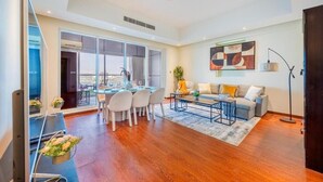A spacious living area with a dining table, sofa, and a large window offering a city view. - Unit 805 Jamam Residence (Abu Dhabi)