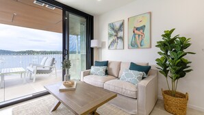 Un salon moderne avec un canapé, une table basse et une plante en pot.