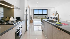 Una cocina moderna con una isla central, estufa y un amplio ventanal con vistas a la ciudad.