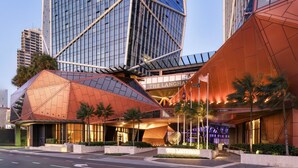 The Langham hotel with a distinctive geometric facade and a modern glass building in the background. - Jewel Luxury Beachside 2-Bed with Water View (Surfers Paradise)