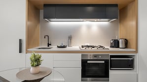 A modern kitchen with a stainless steel range, built-in oven, and microwave. - 1BR Apartment Near CBD with Pool (Docklands)