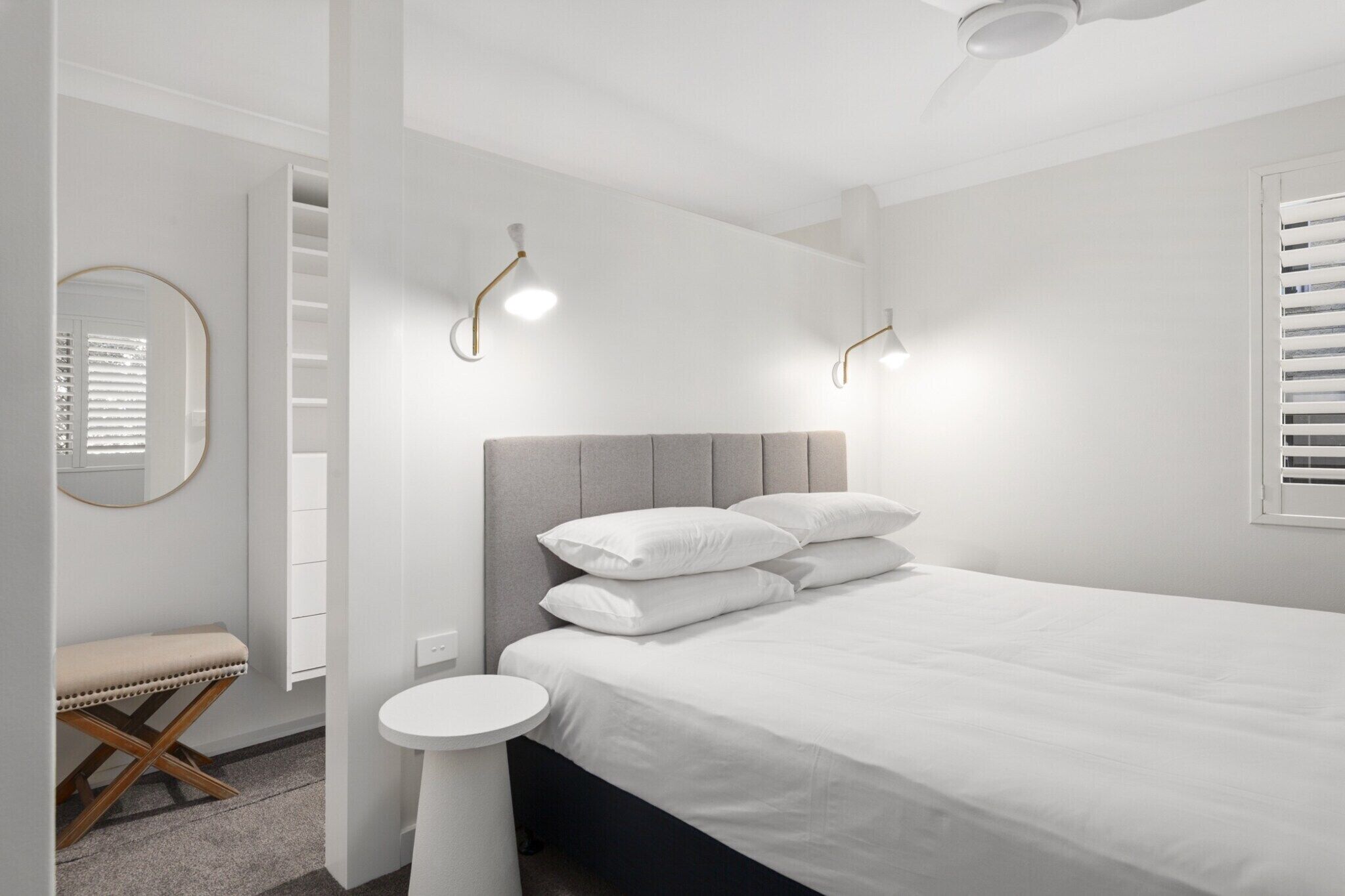 Una camera da letto moderna con un letto, un comodino e una panca.