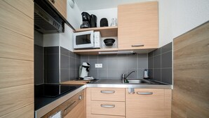 A compact kitchen with a microwave, coffee maker, and a sink. - C. du Verdon N°3307 - 2P6 (Allos)