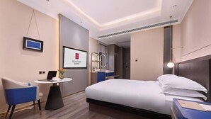 A modern hotel room with a bed, a desk, a chair, a TV, and a bathroom visible through an open door. - ECHARM PLUS Hotel (Guangzhou Dart International Center Changgang Metro Station) (Guangzhou)