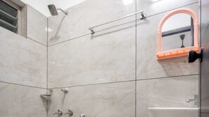 A bathroom with a toilet, a shower, and a sink. - FORA INN (Kanayannur)