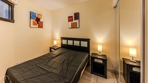 A hotel room with a bed, bedside tables, and wall art. - Carre Marine N°207 - 2P4 (Mandelieu-la-Napoule)