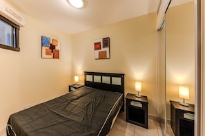 A hotel room with a bed, bedside tables, and wall art. - Carre Marine N°207 - 2P4 (Mandelieu-la-Napoule)