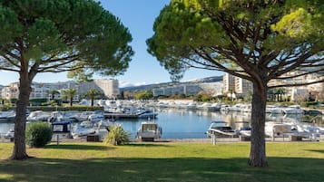 A marina with boats docked, surrounded by trees and buildings in the background.