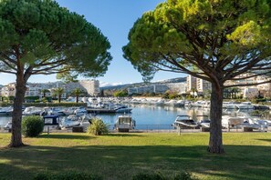 A marina with boats docked, surrounded by trees and buildings in the background. - Carre Marine N°107 - 2P4 (Mandelieu-la-Napoule)